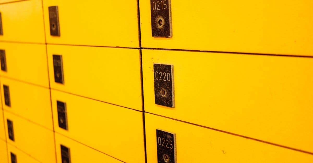 Close-up view of yellow lockers with numbered plaques, ideal for storage or security themes.
