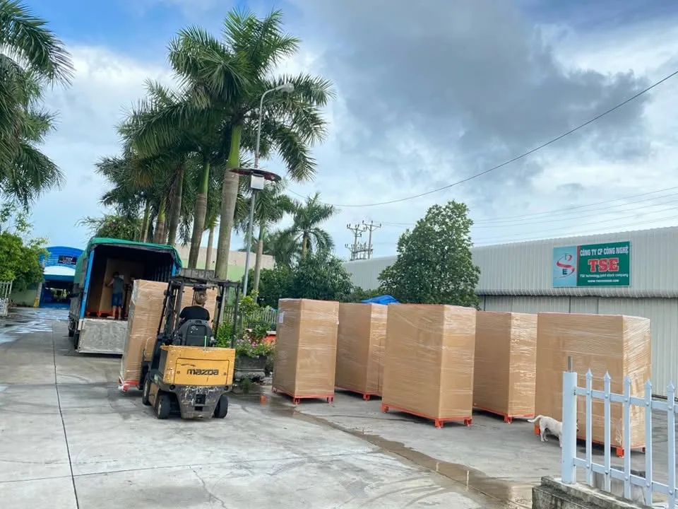 Xe nâng đưa kiện gỗ đóng máy bán hàng tự động lên xe tải tại xưởng TSE để giao đi