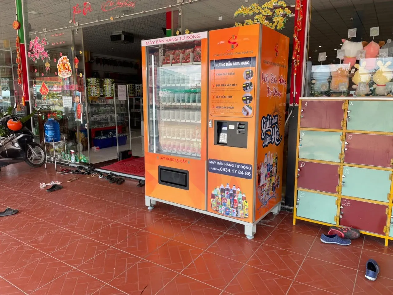 Máy bán hàng tự động cạnh cụm tủ locker mini nhiều màu trước cửa hàng