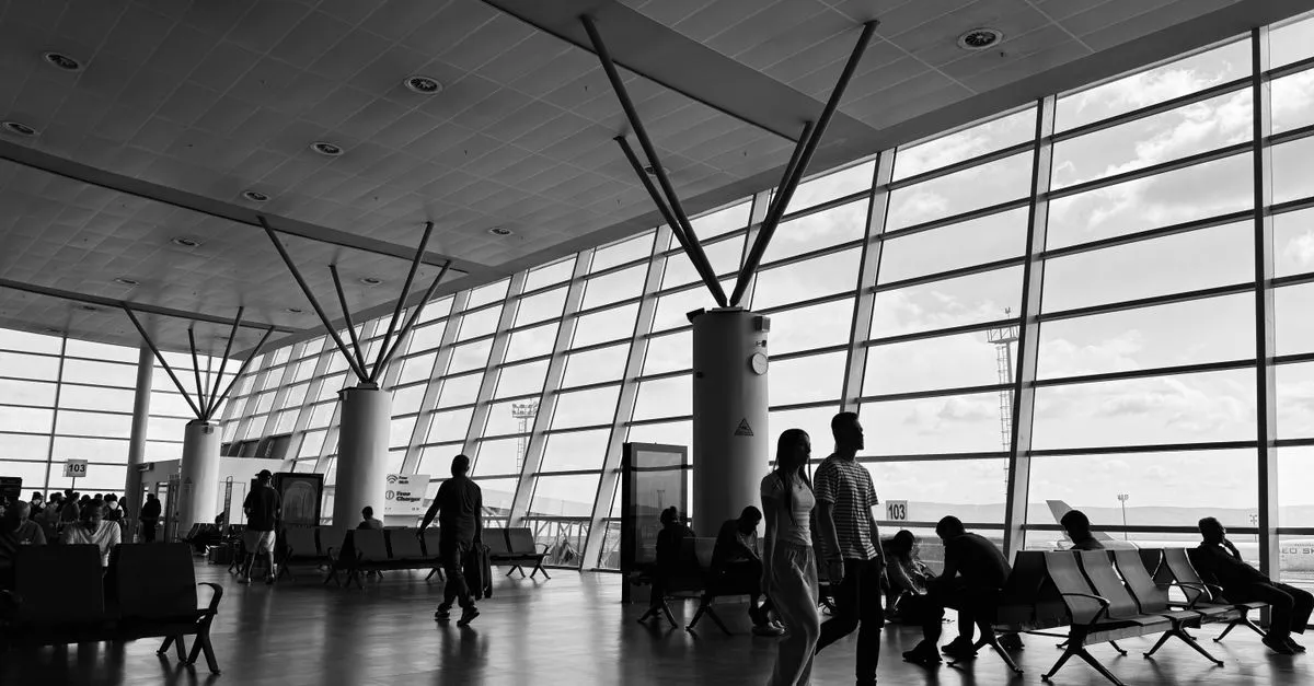 Passenger using self-service check-in kiosk at airport for convenient travel experience.