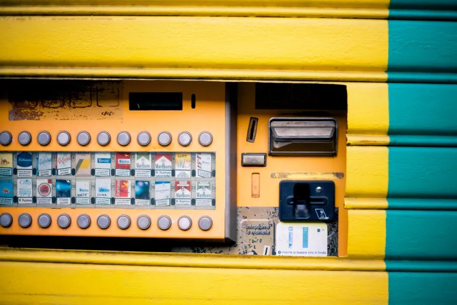 Detailed view of a vibrant yellow and green cigarette vending machine interface.