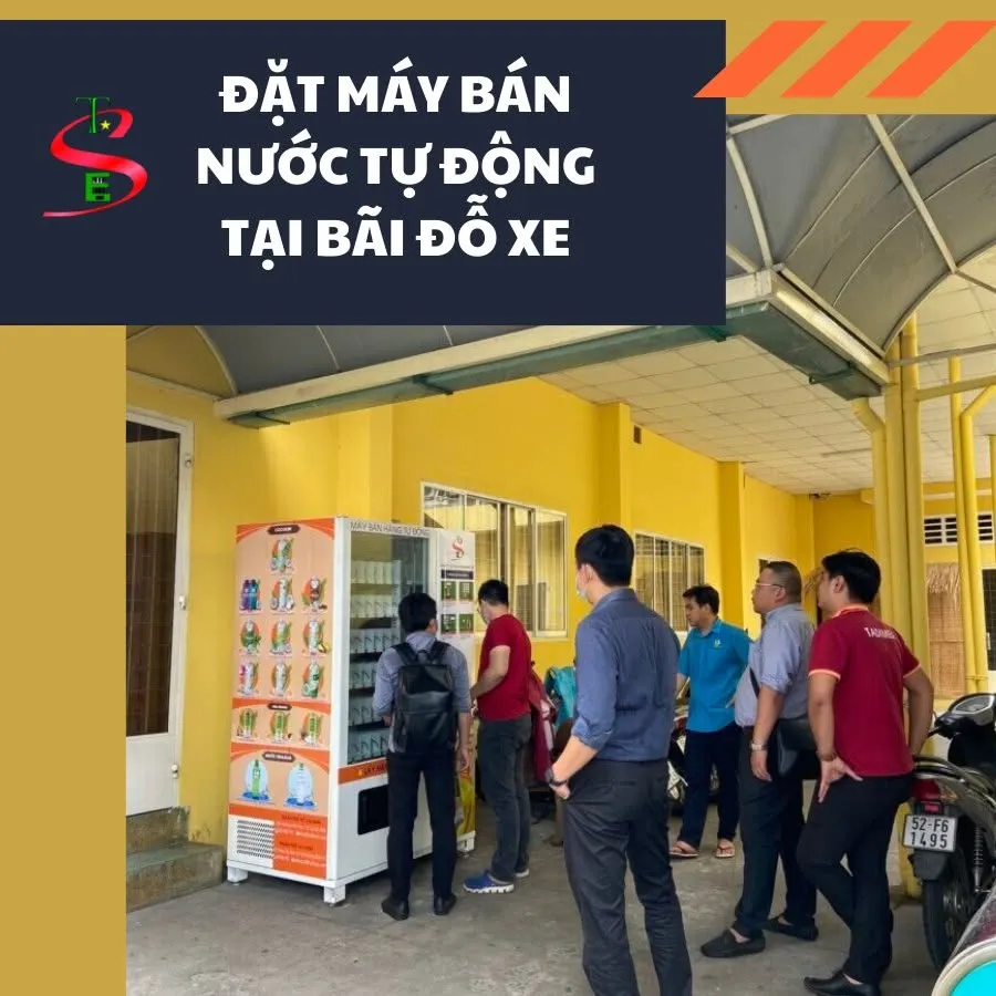 Máy bán nước tự động đặt tại bãi đỗ xe có mái che, nhóm khách hàng đang tìm hiểu máy