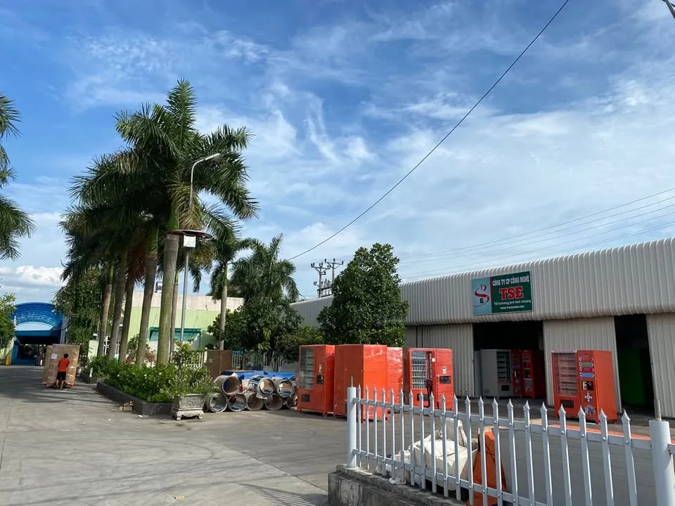 Sân xưởng TSE dưới trời nắng với các máy bán hàng tự động màu đỏ xếp dọc hàng rào chờ lắp đặt