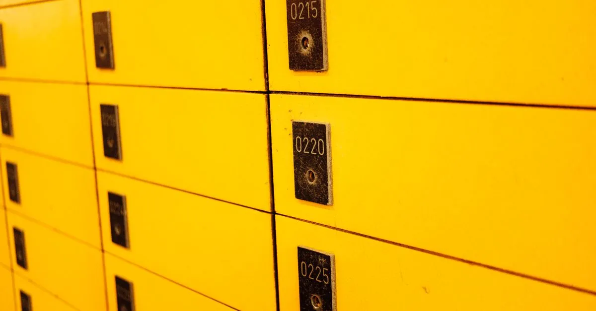Close-up view of yellow lockers with numbered plaques, ideal for storage or security themes.