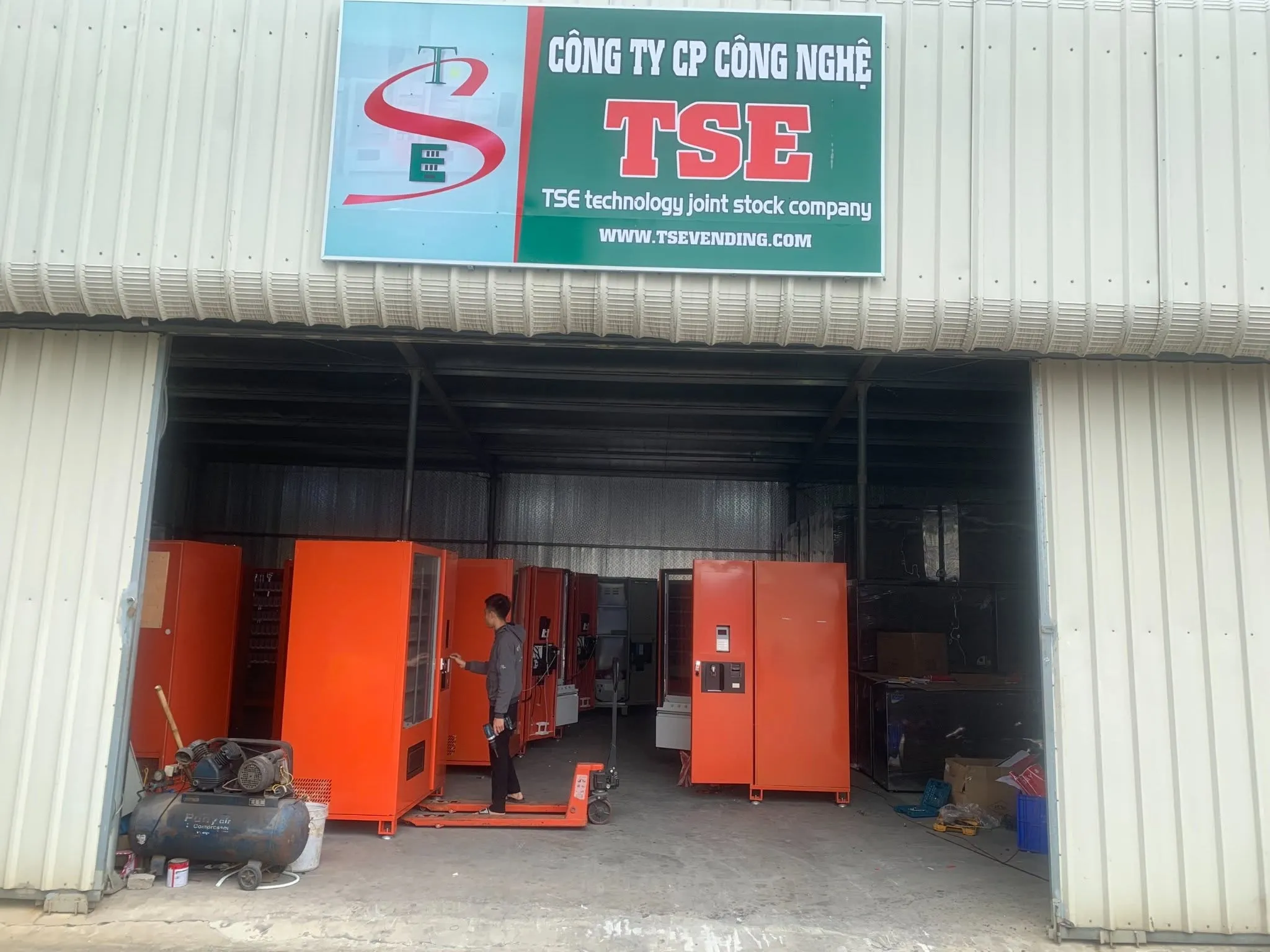 Xưởng sản xuất máy bán hàng tự động của TSE Vending với dãy máy màu cam đang lắp ráp
